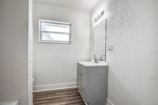 a bathroom with a sink and mirror with toilet