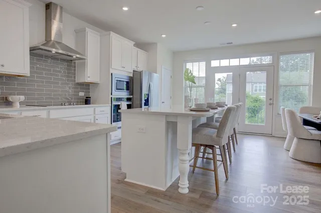 a dining room with furniture a large window and wooden floor