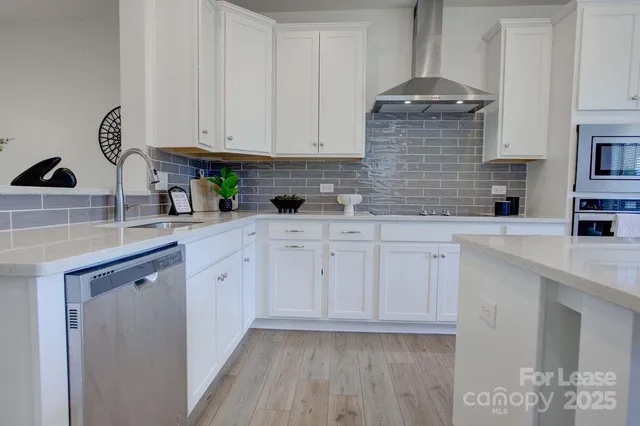 a kitchen with white cabinets and sink