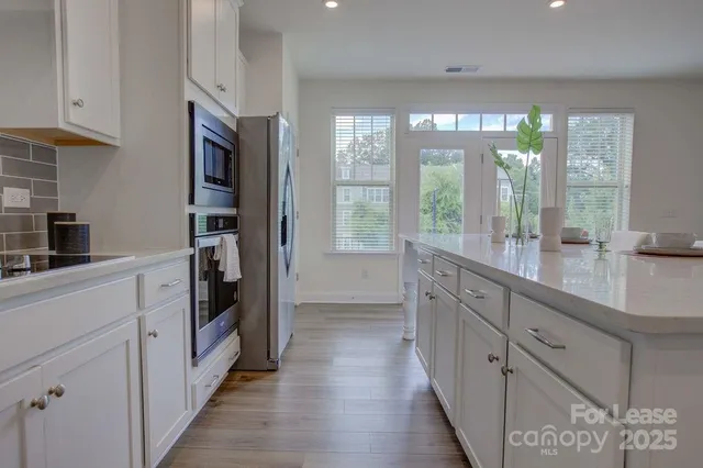a kitchen with granite countertop a refrigerator and a sink