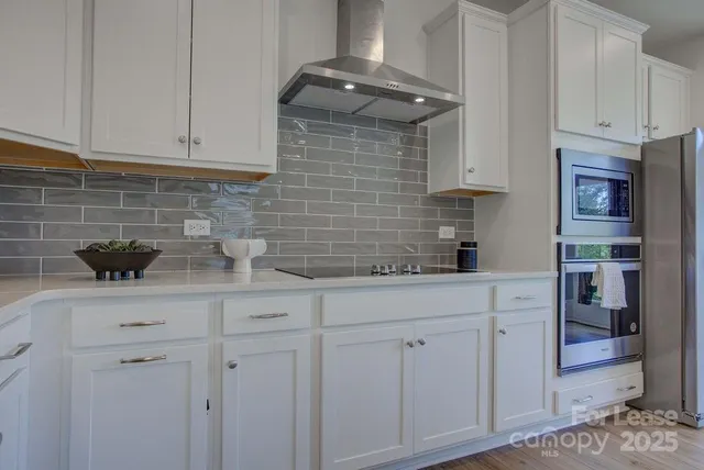 a kitchen with stainless steel appliances white cabinets and a sink
