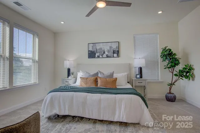 a bedroom with bed and a potted plant