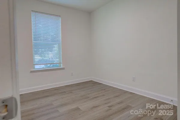 a view of a small space with wooden floor and a window