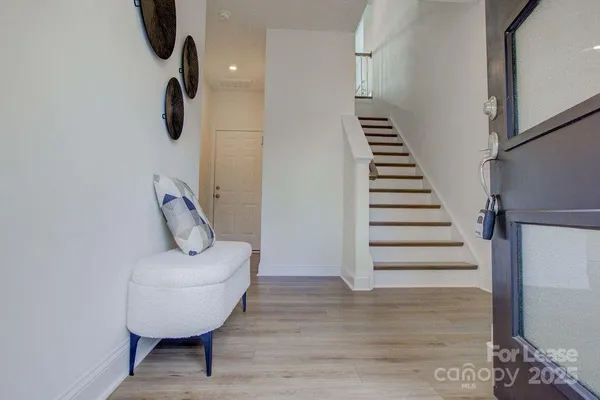 a view of entryway and hall with wooden floor