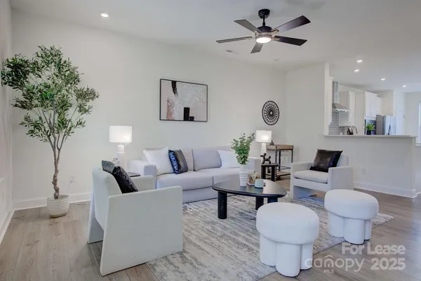 a living room with furniture a chandelier and a potted plant