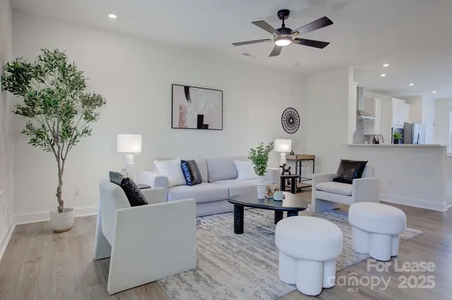 a living room with furniture a chandelier and a potted plant