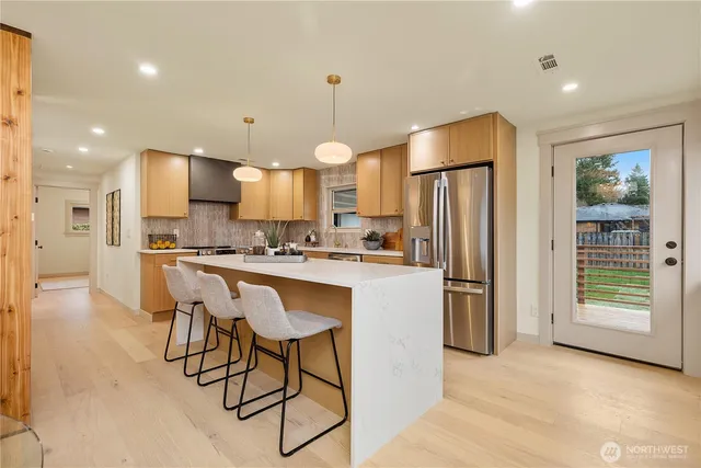 a kitchen with stainless steel appliances granite countertop a refrigerator and a stove top oven