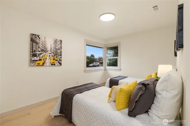 a bedroom with a bed and painting on the wall