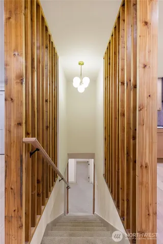 a view of a hallway with wooden floor and staircase