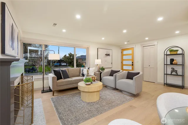 a living room with fireplace furniture and a view of kitchen