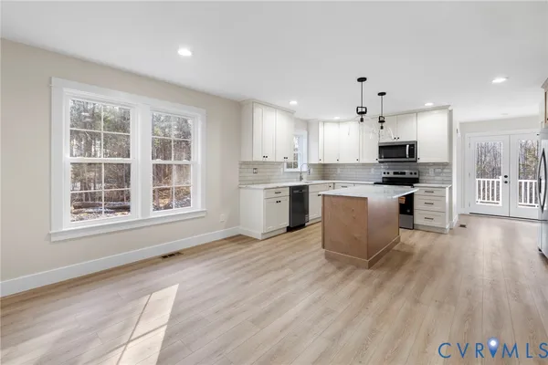 a large kitchen with cabinets wooden floor and stainless steel appliances