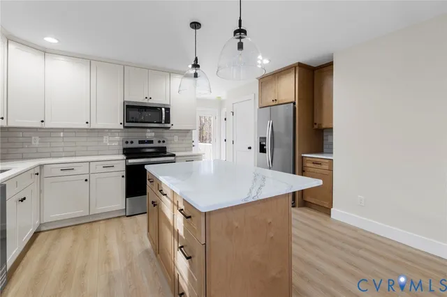 a kitchen with kitchen island a sink appliances and cabinets