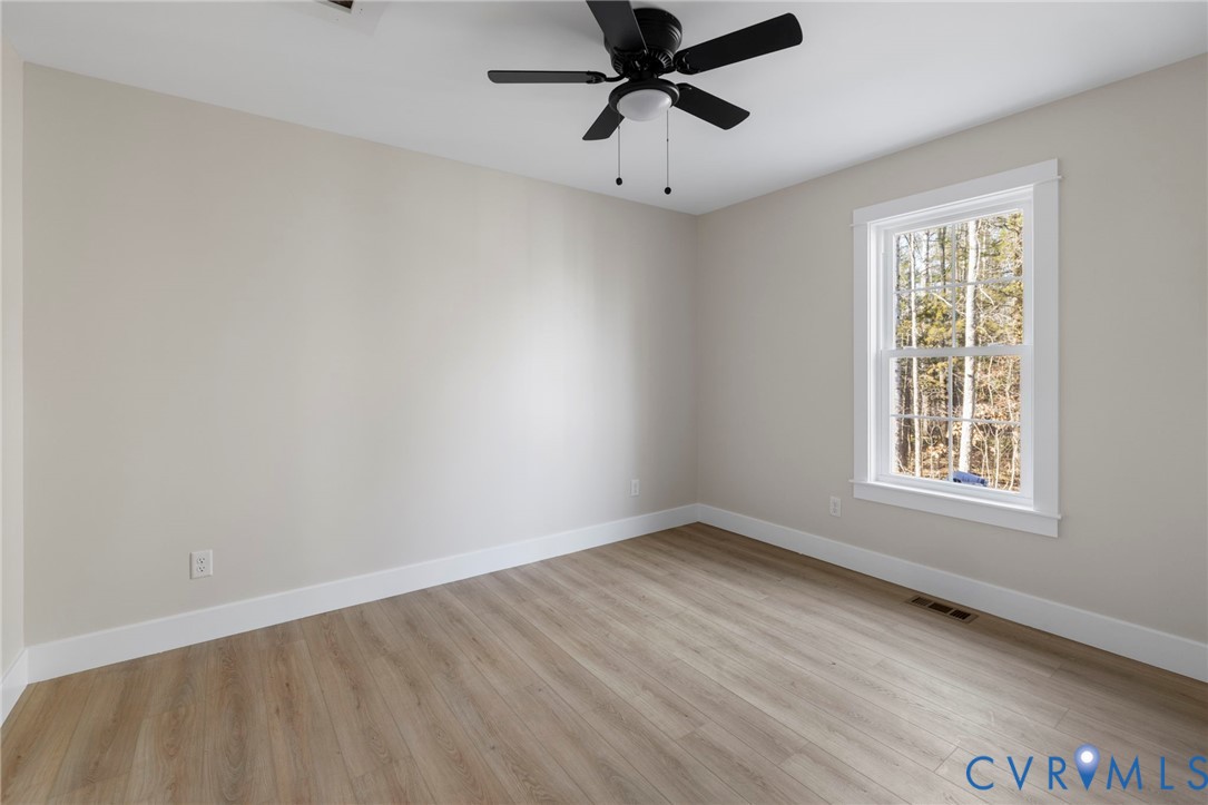 320 Vogel Road Cumberland, VA 23040 - Photo 24 of 28 an empty room with wooden floor fan and windows