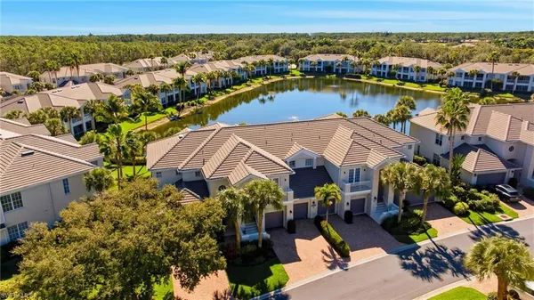 an aerial view of residential houses with outdoor space and lake view