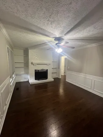 a view of a livingroom with wooden floor and a fireplace