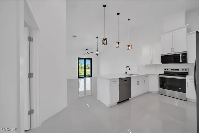 a view of a kitchen with refrigerator and chairs