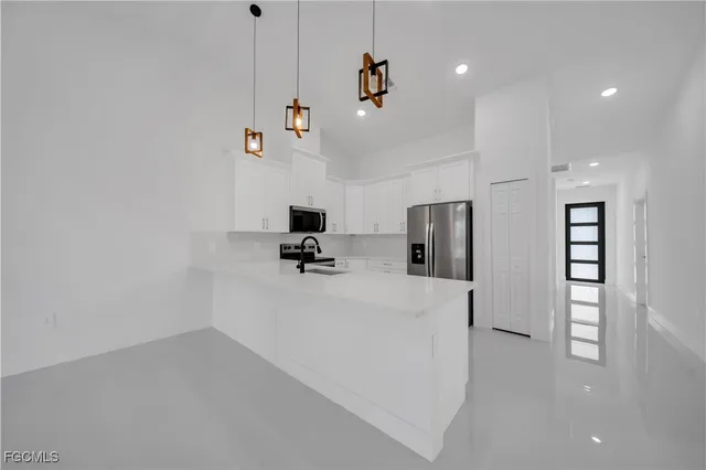 a view of kitchen with microwave and a refrigerator