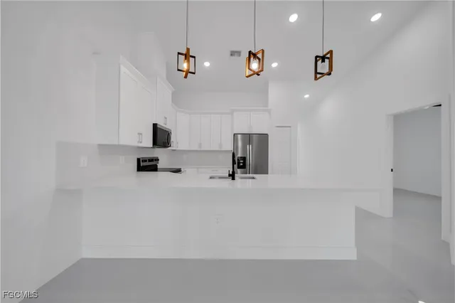 a kitchen with kitchen island a sink stainless steel appliances and cabinets