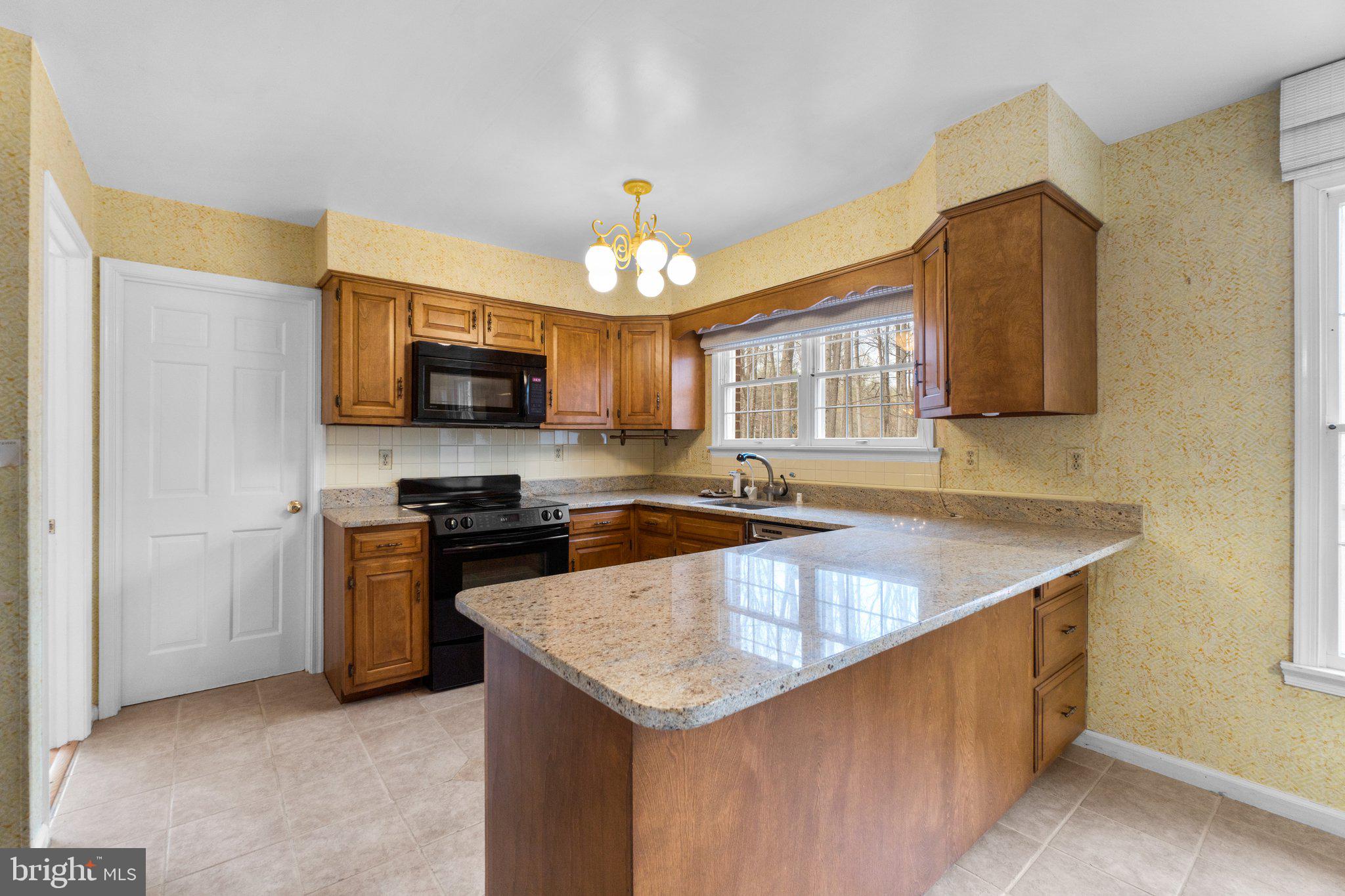 12238 Etchison Road Ellicott City, MD 21042 - Photo 15 of 49 a kitchen with stainless steel appliances granite countertop a sink a stove and a microwave