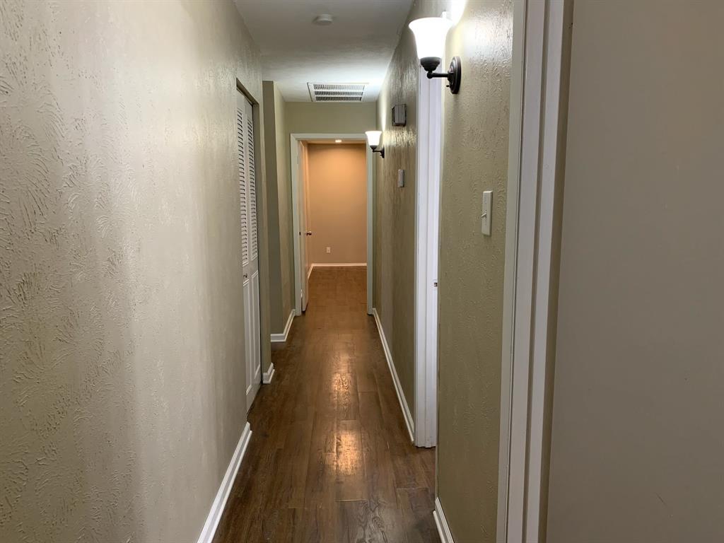 13652 Flagstone Lane Dallas, TX 75240 - Photo 13 of 15 Corridor with dark wood-type flooring and a textured wall