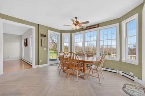 a dining room with furniture a chandelier and wooden floor