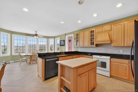 a kitchen with a stove a sink a counter top space and cabinets