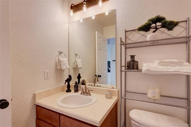 a bathroom with a sink toilet and mirror