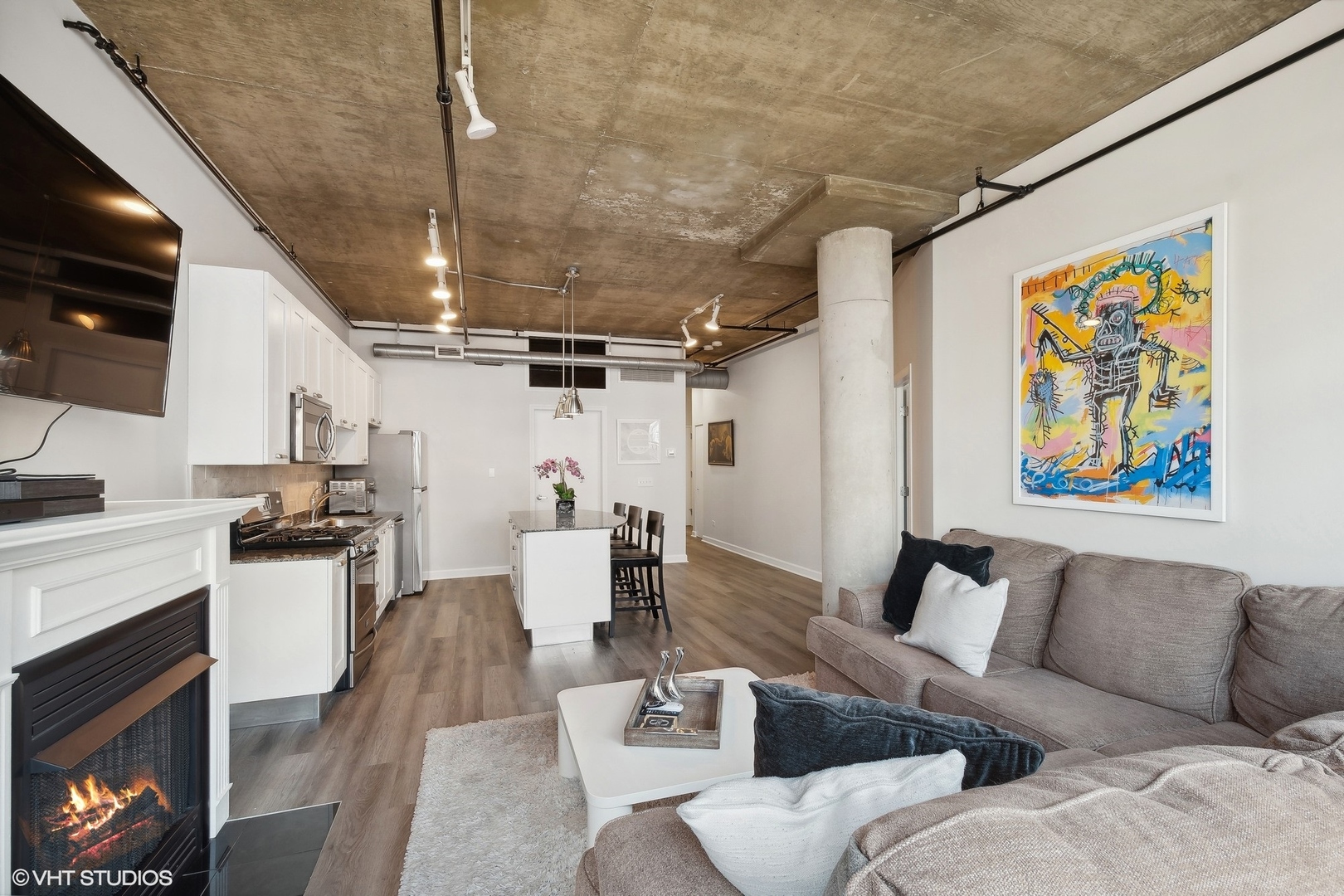 111 South Morgan Street, Unit 607 Chicago, IL 60607 - Photo 5 of 12 a living room with stainless steel appliances furniture a fireplace and a flat screen tv