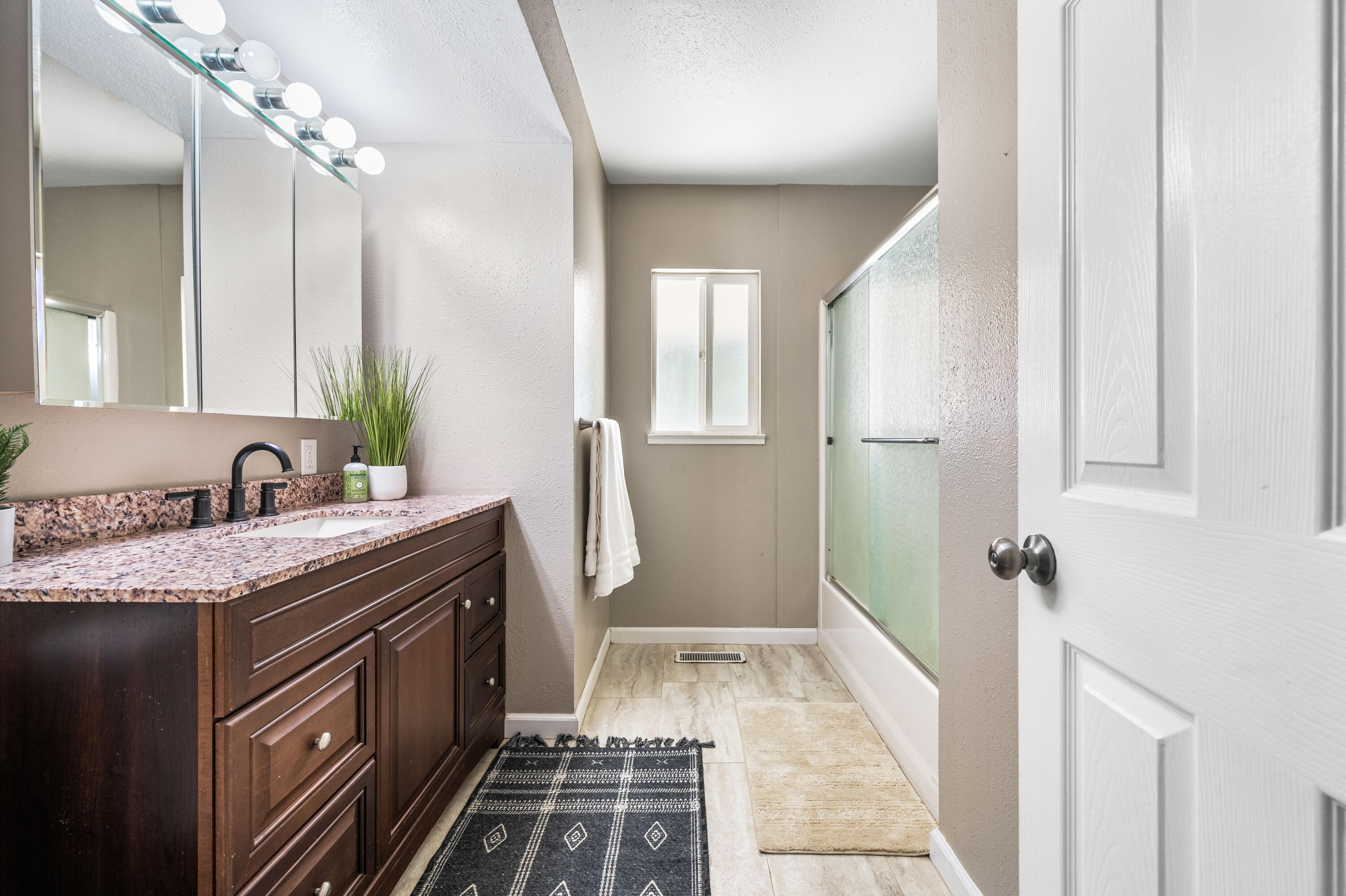 8631 Prospectors Road Redding, CA 96001 - Photo 31 of 41 a bathroom with a granite countertop sink a mirror and a shower