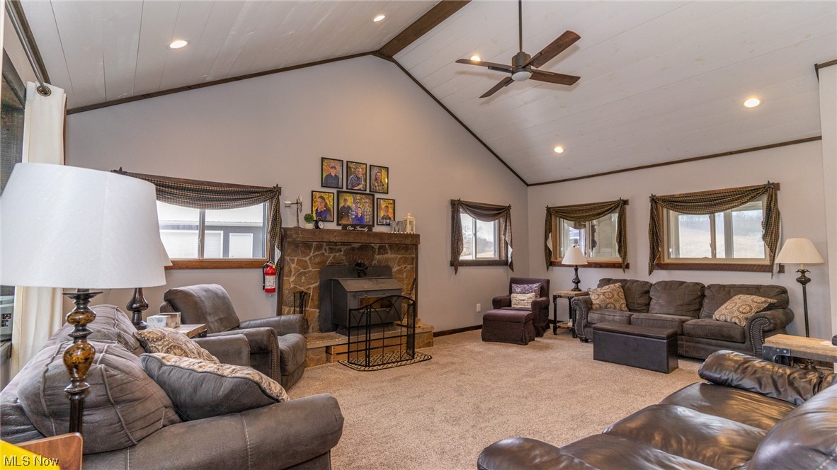 13962 Nickel Plate Road Logan, OH 43138 - Photo 12 of 46 Carpeted living room with a wealth of natural light, beamed ceiling, a fireplace, and ceiling fan