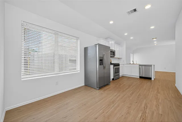 a view of a kitchen with a sink and a refrigerator