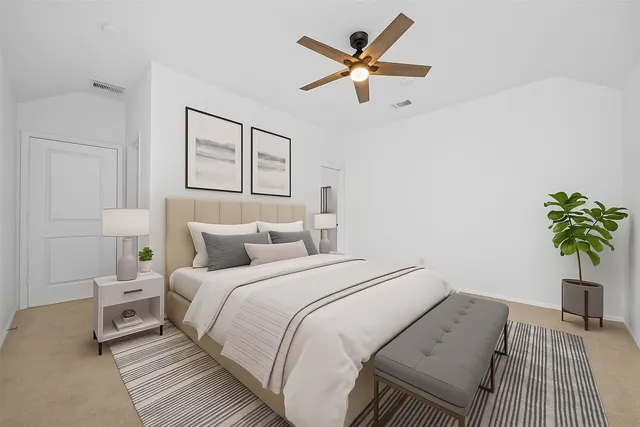 a bedroom with a large bed and a potted plant