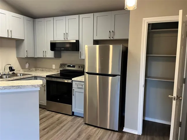 a kitchen with a refrigerator stove and white cabinets
