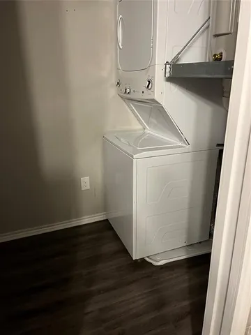 a utility room with wooden floor washer and dryer