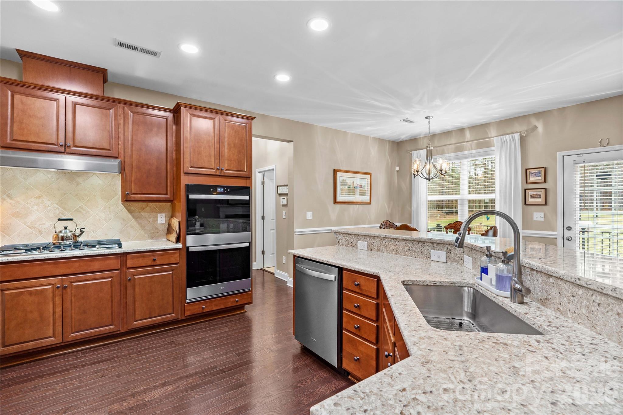 106 Dayvault Cut Road Troutman, NC 28166 - Photo 14 of 48 a kitchen with kitchen island granite countertop a sink cabinets and wooden floor
