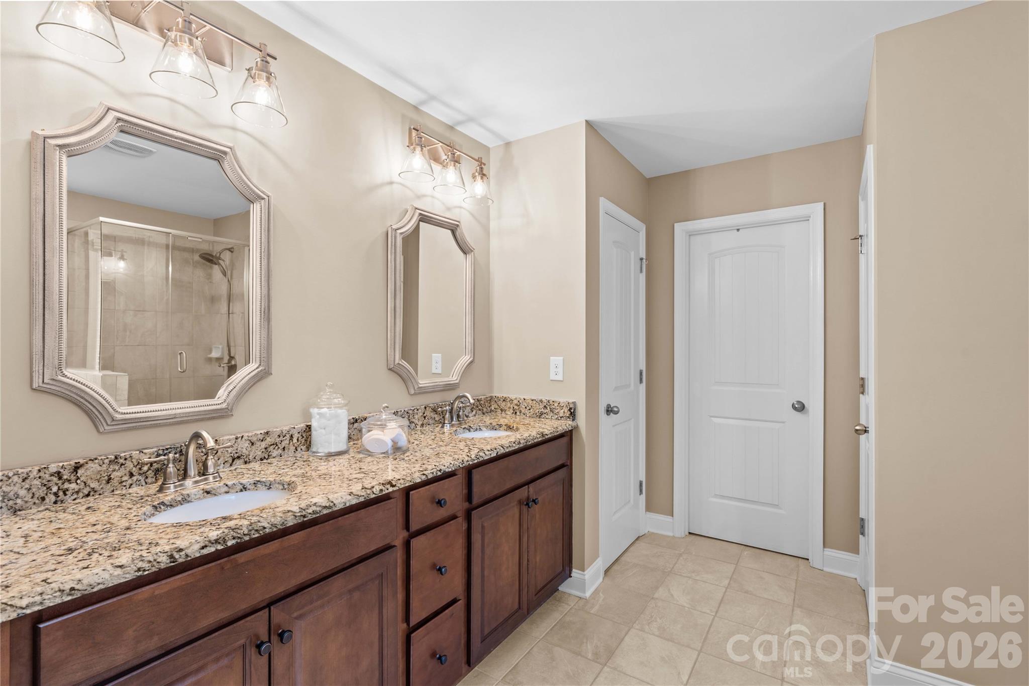 106 Dayvault Cut Road Troutman, NC 28166 - Photo 30 of 48 a bathroom with a granite countertop double vanity sink and a mirror