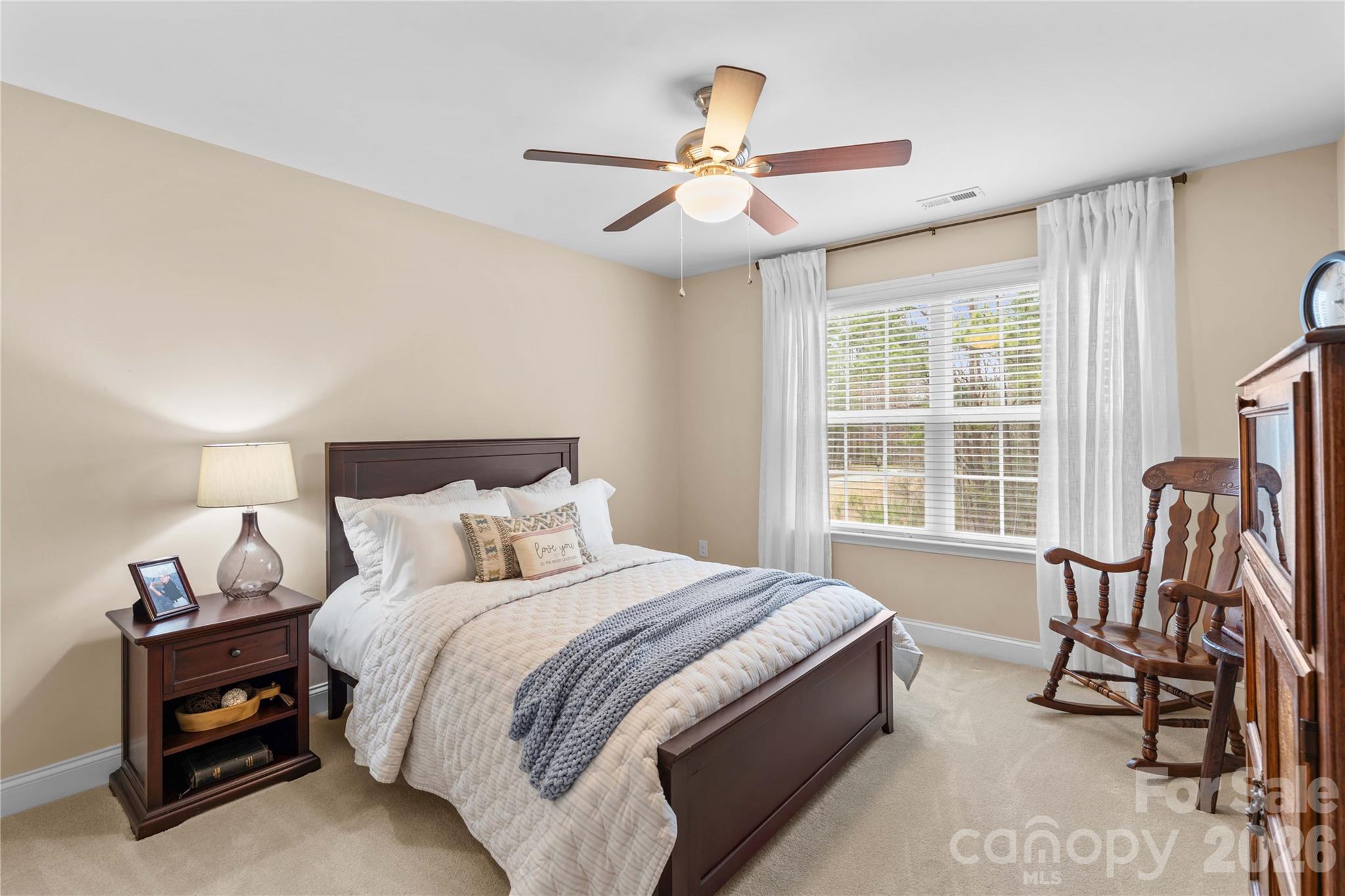 106 Dayvault Cut Road Troutman, NC 28166 - Photo 32 of 48 a bedroom with a bed a chair and a large window