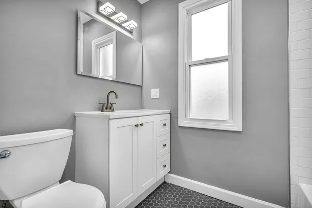 a bathroom with a toilet sink and mirror