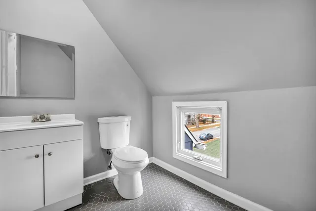 a bathroom with a toilet sink and mirror