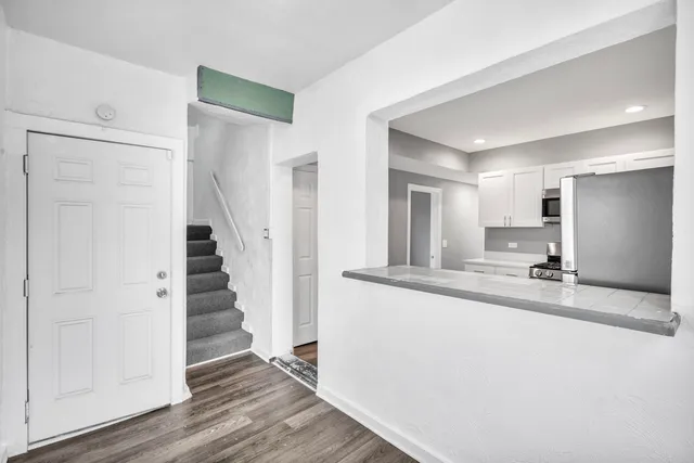 a view of a kitchen with wooden floor and staircase