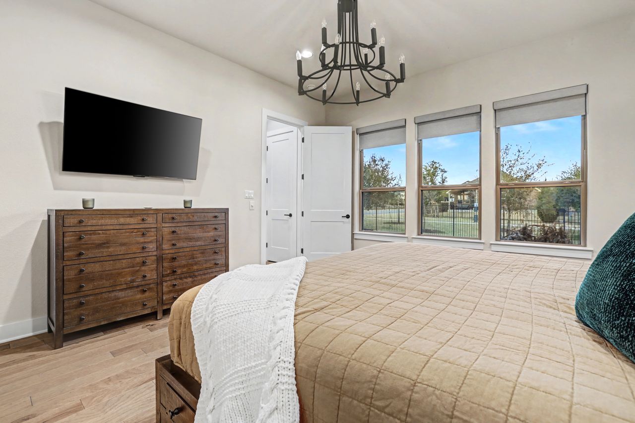 2408 Nate's Place Georgetown, TX 78633 - Photo 19 of 40 Bedroom with light wood finished floors and a chandelier