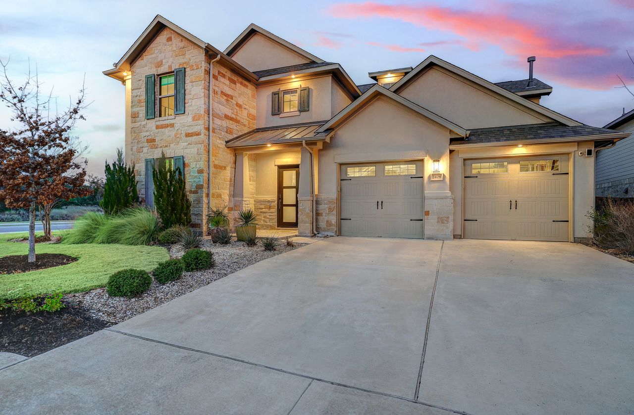 2408 Nate's Place Georgetown, TX 78633 - Photo 3 of 40 View of front of home featuring stone siding, stucco siding, driveway, and a garage