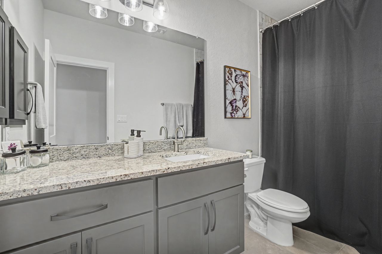 2408 Nate's Place Georgetown, TX 78633 - Photo 32 of 40 Full bath featuring a shower with curtain, vanity, and a textured wall