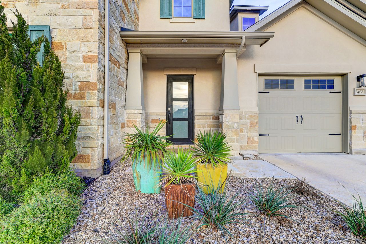 2408 Nate's Place Georgetown, TX 78633 - Photo 6 of 40 Doorway to property featuring stone siding, stucco siding, driveway, and a garage