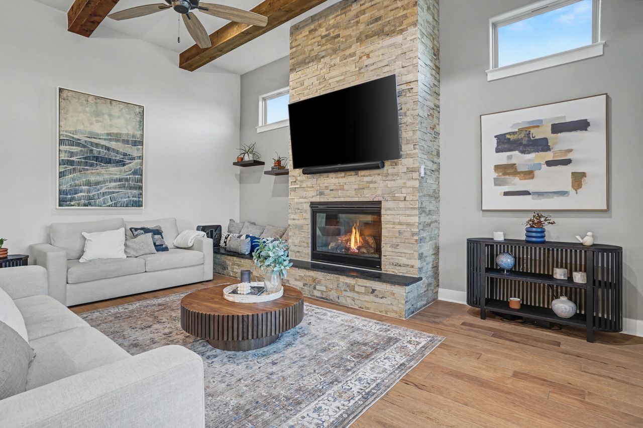 2408 Nate's Place Georgetown, TX 78633 - Photo 10 of 40 Living room with light wood-style floors, ceiling fan, a stone fireplace, and radiator