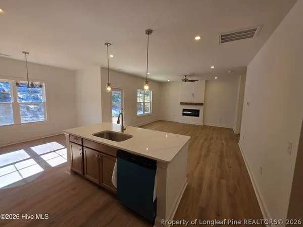 a kitchen with a sink a faucet a stove and wooden floor