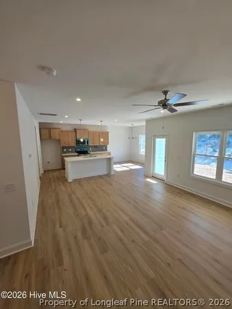 a view of a living room a kitchen with a wooden floor
