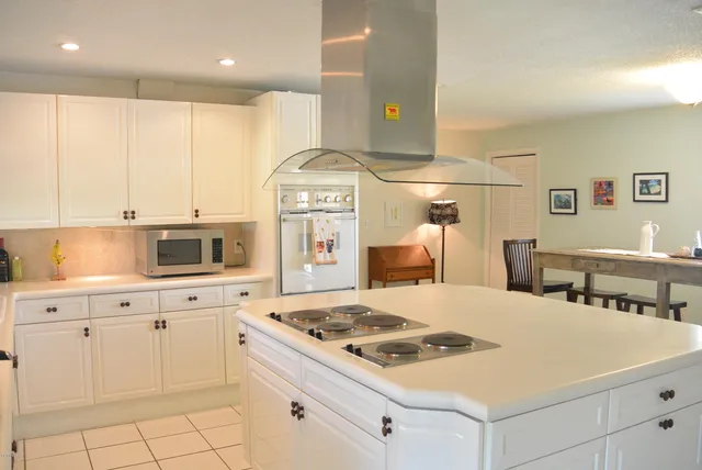 a kitchen with white cabinets and appliances