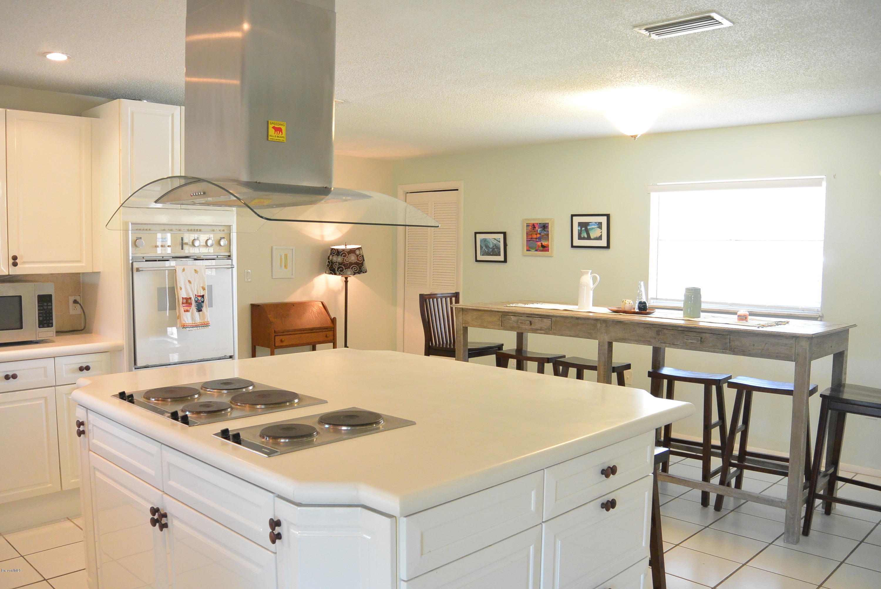 9 West Point Drive Cocoa Beach, FL 32931 - Photo 14 of 28 a kitchen with a stove a table and chairs in it