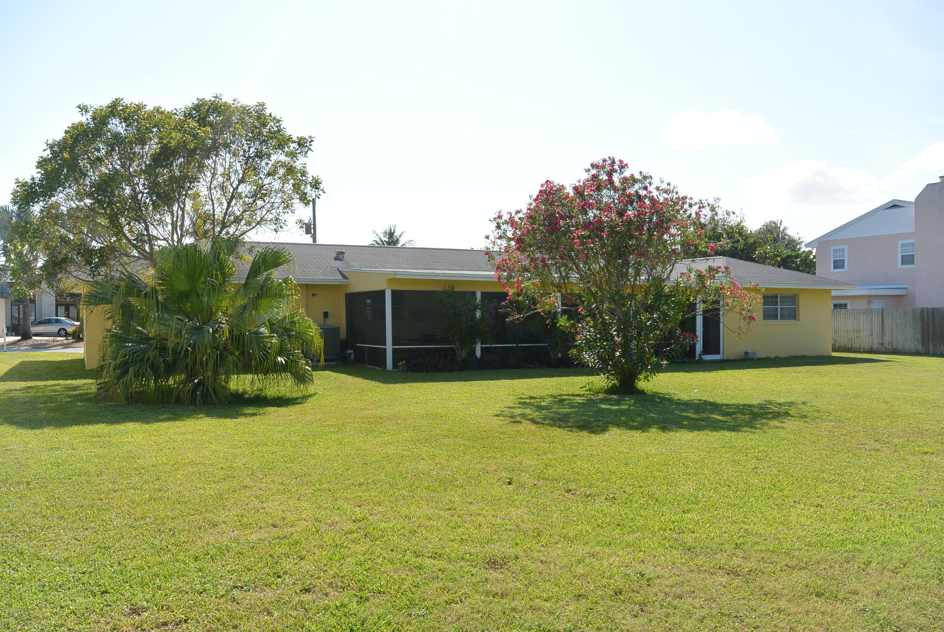 9 West Point Drive Cocoa Beach, FL 32931 - Photo 23 of 28 a front view of a house with a yard and garage